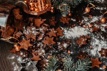 A rustic holiday setting featuring a jar of homemade cookies, surrounded by cinnamon sticks and festive lights. Pine branches add a cozy, warm atmosphere perfect for the winter season.