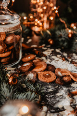 Traditional Christmas gingerbread cookies on a dark background with bokeh lights. Vertical photo, Holiday Season activity.