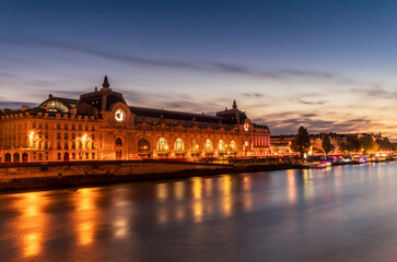 Obraz premium The Orsay museum in Paris at sunset reflecting on the Seine river