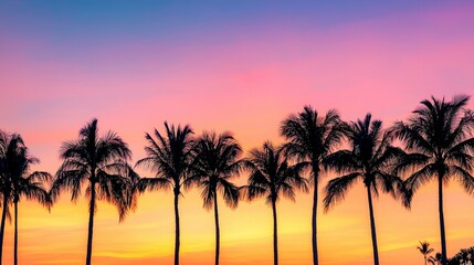 Naklejka premium Silhouetted palm trees against a gradient sunset sky with vibrant colors, capturing the tranquil beauty of a tropical island evening and serene vacation vibes