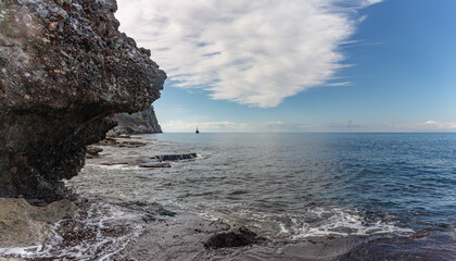 Panoramic view of the Mediterranean Sea with a ship sailing along the rocky shores in the background.
