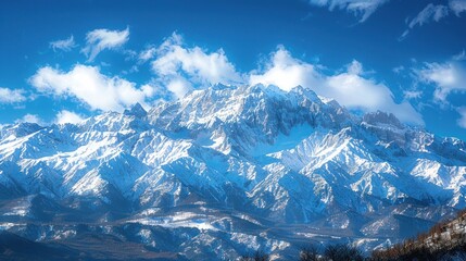 Obraz premium Majestic Snow-Capped Mountain Range Under a Vibrant Blue Sky