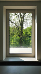 A window view showcasing lush greenery and a tree, promoting a serene indoor-outdoor connection.