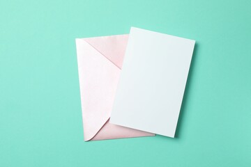 Paper card with envelope on color background. Empty greeting card for text design