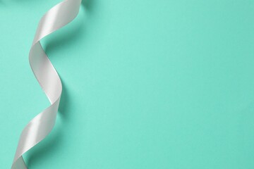 Pink silk ribbon on color background