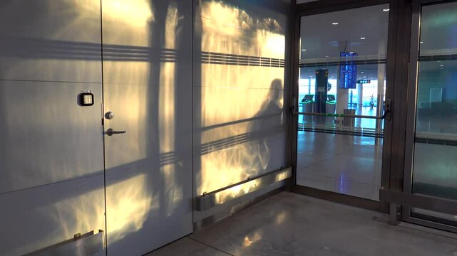 Stockholm, Sweden The shadow of an automatic door opening and closing with passenger shadows going by in a public Arlanda airport hallway 