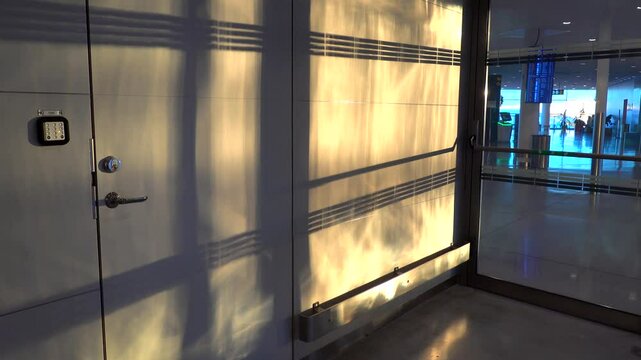 Stockholm, Sweden The shadow of an automatic door opening and closing with passenger shadows going by in a public Arlanda airport hallway 