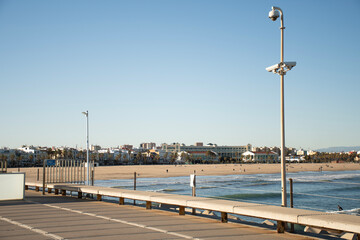view of the beachfront de las arenas beach in valencia, spain on the mediterranean sea with hotels and resorts in the background, pier