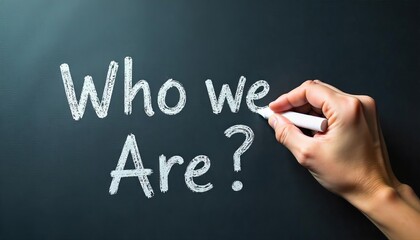 Hand holding white chalk writing "Who we are". Highlighting key business principles.