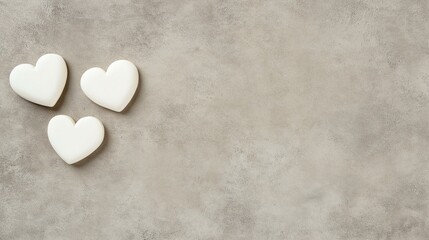 Obraz premium Three white heart shapes on a textured gray background, symbolizing love, affection, and care. Ideal for romantic, social, or wellness themes.