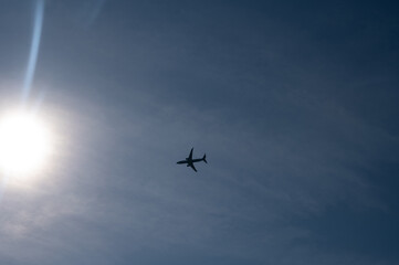 An airplane in the sky with sun