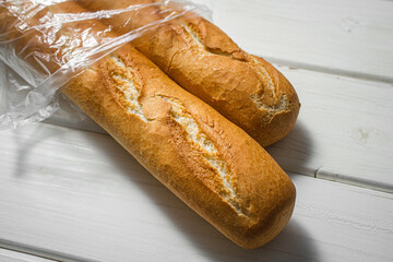 Fresh baguette on a light table. Fresh bread product