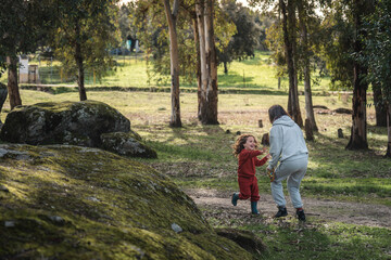 A woman and a child are playing in a park