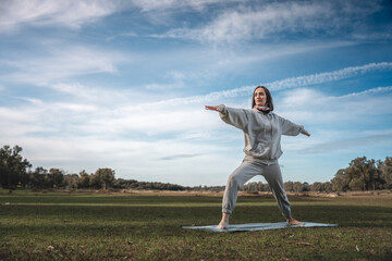 A woman is doing yoga in a field