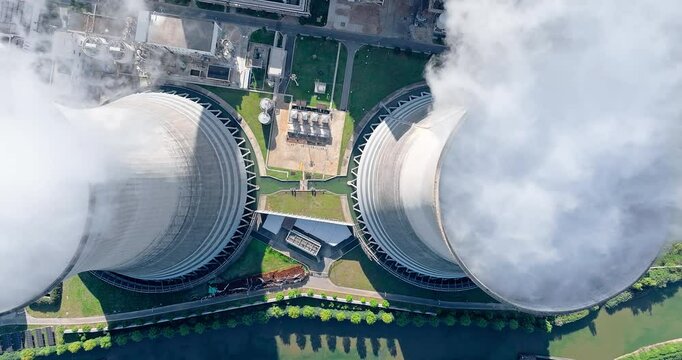 Aerial view of steam rises from the huge chimneys of the operating power plant