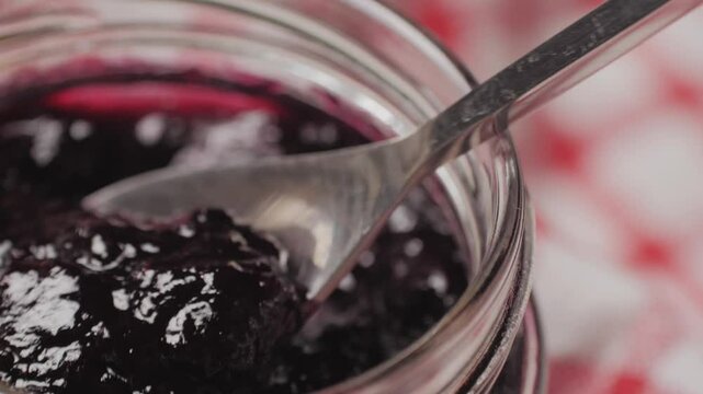 Cooking blueberry raspberry berrie jam with sugar, boiling marmalade, Jar of raspberry jam and fresh berries with leaves on a white wooden table.