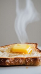 hot toast with a melting piece of butter on top, steam from the butter