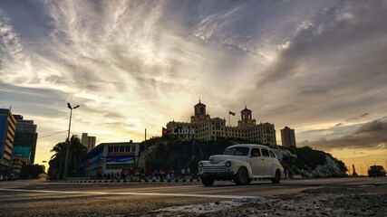 Sunset and a passing old car in Havana 