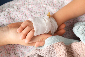 Doctor and child with intravenous drip at hospital, closeup