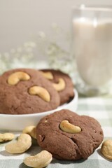 Tasty chocolate cookies with cashew on table, closeup