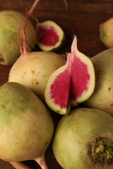 Whole and cut fresh turnips on table, closeup