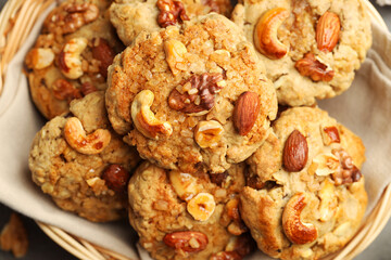 Tasty cookies with nuts in basket on table, top view