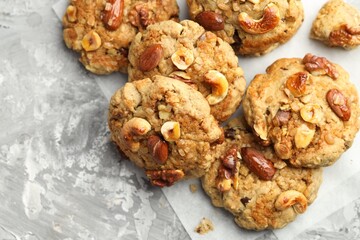 Tasty cookies with nuts on grey table, flat lay. Space for text