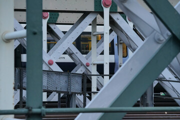 Heavy steel railroad bridge construction, train visible in background