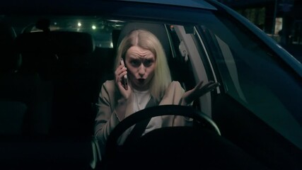 Distracted Caucasian car driver businesswoman female girl business woman transport owner speaking smartphone talk gesturing cellphone conversation risk driving inside automobile late evening highway