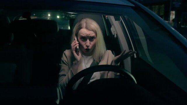 Distracted Caucasian car driver businesswoman female girl business woman transport owner speaking smartphone talk gesturing cellphone conversation risk driving inside automobile late evening highway