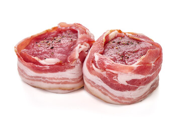 Raw bacon-wrapped meat medallions with seasoning, isolated on white background.