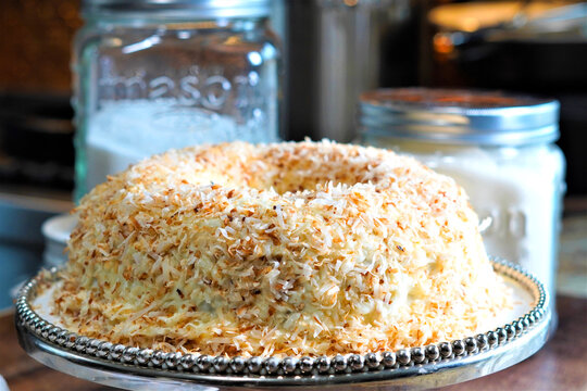 Making the most delicious and beautiful toasted coconut cake for a birthday party. Buttercream icing on this dessert and topped with flaky sweet coconut.