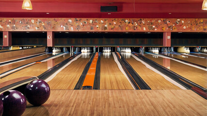 Bowling ball hitting all ten pins in a bowling alley, showcasing energy and precision in a perfect strike. Exciting action scene in sports, dynamic indoor recreational activity.
