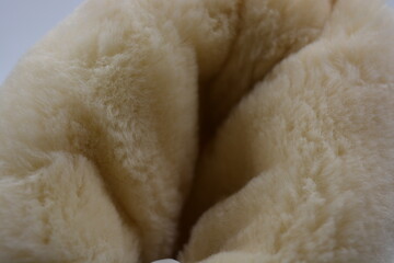 Things, material objects, fluffy fur, fur background. A warm, fluffy, brown, golden background in the form of animal skins made of synthetic materials.