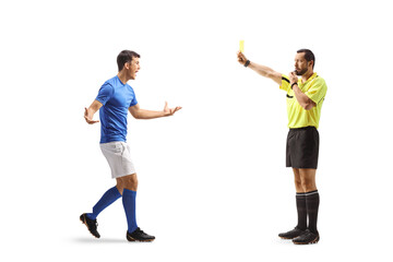 Referee running with a yellow card towards an angry football player