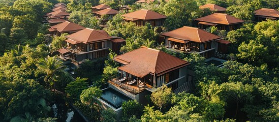 Aerial view of a luxury resort with private pools and lush tropical vegetation.