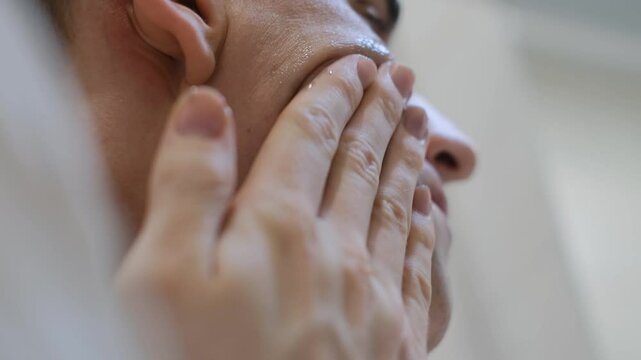 Close up of a man applying face wash to his face, close up