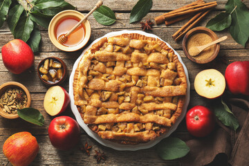 Homemade apple pie and ingredients on wooden table, flat lay
