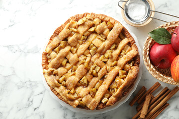 Homemade apple pie and ingredients on white marble table, flat lay