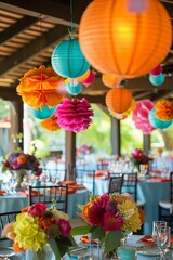 A colorful party with many tables and chairs. The tables are decorated with flowers and colorful lanterns