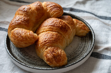 Fresh baked two buttered croissants served in restaurant for continental or French breakfast close up