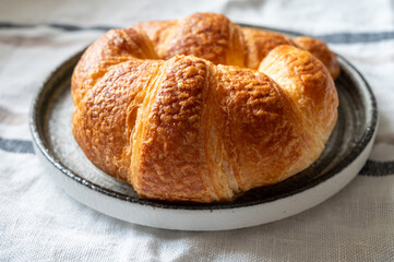 Fresh baked two buttered croissants served in restaurant for continental or French breakfast close up