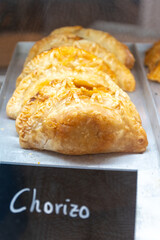 Traditional Spanish and Latin American pies empanadas with different fillings, at farmer's market in bakery, wirh Spanish chorizo sausage