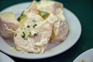 Vegetarian Spanish food, boiled potatoes with alioli sauce and parsley served as tapa in old tavern, Andalusia, Spain