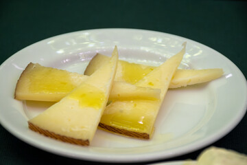 Tasting of Spanish cheeses, manchego curado cheese on white board