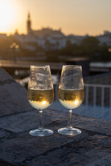 Drinking of cava or champagne sparkling wine on outdoor roof terrace with view on central part of old Sevilla, Andalusia, Spain sunset
