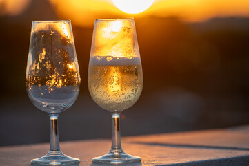 Drinking of cava or champagne sparkling wine on outdoor roof terrace with view on central part of old Sevilla, Andalusia, Spain sunset