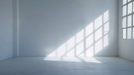Bright sunlight casts geometric patterns on the floor of a minimalist empty room with large windows and white walls.
