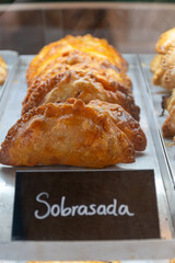 Traditional Spanish and Latin American pies empanadas with different fillings, at farmer's market in bakery, wirh Spanish sobrasada sausage