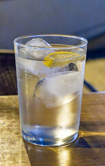 Glasses of cold mineral sparkling water served outdoor with ice cubes in cafe at night in historical Triana district, Sevilla, Spain